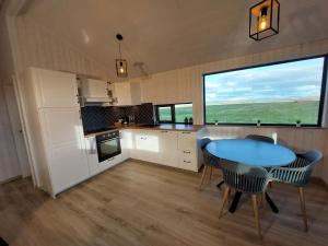 a kitchen with a table and chairs and a large window at Iceland Inn Cabin in Selfoss