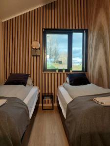 Cette chambre comprend 2 lits et une fenêtre. dans l'établissement Iceland Inn Cabin, à Selfoss