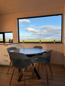a table and two chairs in a room with a large window at Iceland Inn Cabin in Selfoss