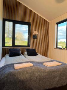 two beds in a room with two windows at Iceland Inn Cabin in Selfoss