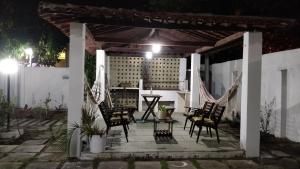 a patio at night with chairs and a table at Casarão na Praia de Camboinha a 250 metros do mar in Cabedelo