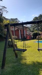 un columpio vacío en un patio con una casa en Canto Alto, Encanto en Petrópolis