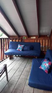 Habitación con sofás y almohadas azules en el suelo de madera. en La Cabaña posada turística, en Buenaventura