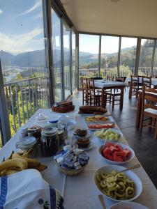 a table with plates of food on top of a balcony at Quinta De Calvelos in Vieira do Minho