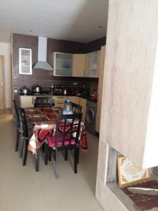 uma cozinha com mesa e cadeiras num quarto em Le 21 Armada Tower em Bouznika