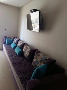 um sofá num quarto com uma televisão na parede em Le 21 Armada Tower em Bouznika