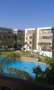 uma grande piscina em frente a alguns edifícios em Le 21 Armada Tower em Bouznika