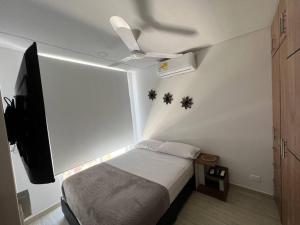 - une petite chambre avec un lit et un ventilateur de plafond dans l'établissement Hermosa casa muy equipada para descansar, à Ricaurte