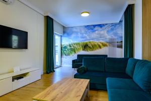 a living room with a blue couch and a view of the beach at Apartament Double Rest 15 in Jastrzębia Góra
