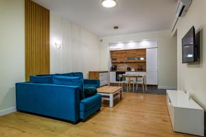 a living room with a blue couch and a kitchen at Apartament Double Rest 15 in Jastrzębia Góra