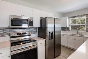 a kitchen with white cabinets and stainless steel appliances at Palmetto Home with Manatee River Access! in Palmetto