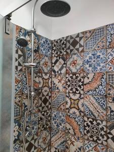uma casa de banho com chuveiro e azulejos coloridos na parede em Volta 8 rooms em Trieste