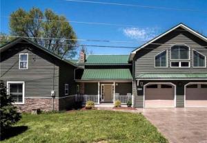 une maison noire avec un toit vert dans l'établissement Salmon River View, à Pulaski