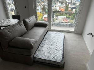 uma sala de estar com um sofá e uma grande janela em Estudio con Terraza y Vista al Lago em San Carlos de Bariloche