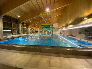 a large swimming pool with a large blue pool at Dachsteinblick apartment in Ramsau am Dachstein