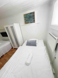biały pokój z 2 łóżkami i oknem w obiekcie Your Ultimate Group Getaway - Central in Vibrant Bislett w Oslo