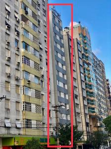 a tall building with red paint on the side of it at Apto frente praia Gonzaguinha in São Vicente