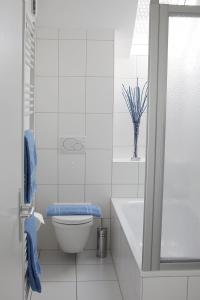 a white bathroom with a toilet and a sink at Residenz Labee in Weil am Rhein