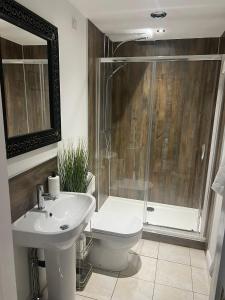 a bathroom with a toilet and a sink and a shower at Boutique Shrewsbury Suites in Shrewsbury