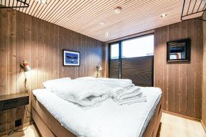 a bedroom with a large bed with white sheets at Rorbuleilighet Lysøysundet 1G in Henningsvær