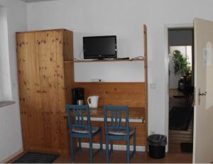 Habitación con 2 sillas y escritorio con TV. en Schönes Zimmer 1 Etage inkl Parkplatz nach Verfügbarkeit en Essen