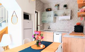 una cocina con una mesa con un jarrón de flores. en La Morada (Gran Alacant) en Gran Alacant