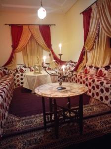 a living room with a couch and a table with candles at Gîte Ait lmaalam chez Ahmed in Skoura