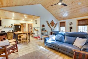 a living room with a blue couch and a kitchen at Beautiful Greig Cabin 2 Mi to Brantingham! in Glenfield
