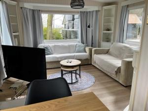 a living room with a couch and a tv at Chalet Stal Veersedam in Kamperland