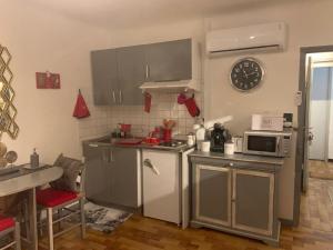 a kitchen with stainless steel appliances and a clock on the wall at Studio de Luxe Aix en Provence in Aix-en-Provence