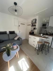 uma sala de estar com um sofá, uma mesa e uma cozinha em Appartement pied dans l’eau em La Seyne-sur-Mer