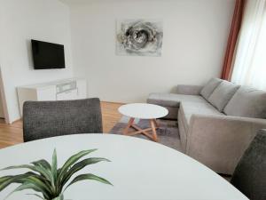 - un salon avec un canapé et une table dans l'établissement Apartment Elena inklusive Garagenplatz, à Vienne