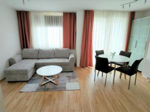 - un salon avec un canapé, une table et des chaises dans l'établissement Apartment Elena inklusive Garagenplatz, à Vienne