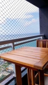 una panca di legno seduta in cima a un balcone di Ponta Negra RN03 a Natal