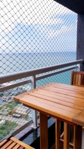 una panca di legno seduta in cima a un balcone di Ponta Negra RN03 a Natal