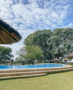 a swimming pool in a park with trees at Apart Club San Pedro in San Pedro +12 photos