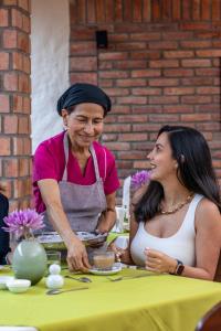 a woman standing next to a woman at a table at Hostal San Francisco in San Cristóbal
