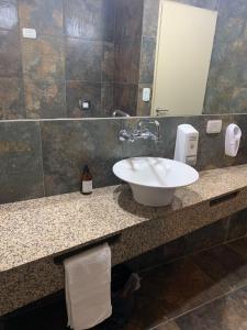 a bathroom with a sink and a mirror at Apart Club San Pedro in San Pedro