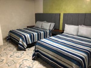 dos camas sentadas una al lado de la otra en una habitación en Suites Incoreli 4, Centro Pachuca de Soto, en Pachuca de Soto