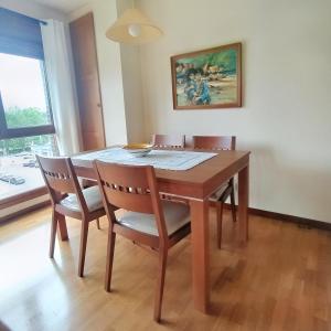 una mesa de comedor con 4 sillas y una pintura en Apartamento Seronda, en Villaviciosa