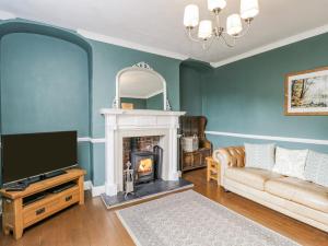 a living room with a couch and a fireplace at Viaduct House in Lydbrook