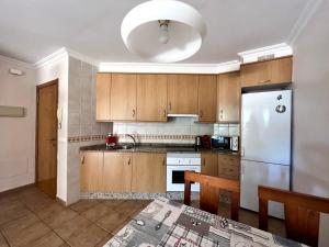 a kitchen with wooden cabinets and a stainless steel refrigerator at Apartament with Garden in La Tejita