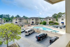 a view of a parking lot with cars and a pool at Little River Condo with Balcony Pool and Hot Tub! in Little River