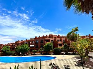 um grande edifício de apartamentos com uma grande piscina em Apartament with Garden em La Tejita