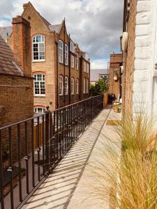 a walkway in a city with buildings and a fence at Your Private Hoxton Apartment Sleeps 3 London Zone 1 in London