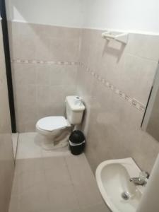 a white bathroom with a toilet and a sink at HOSTEL M&H in Cartagena de Indias