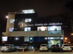 un edificio con coches aparcados delante de él por la noche en Hotel Costa do Atlântico, en João Pessoa