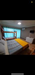 a bedroom with a large bed with a yellow blanket at Guembe al Rio Hostel in Puerto Iguazú