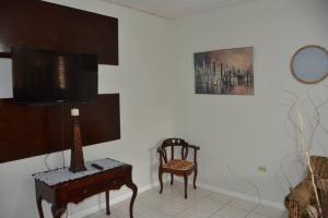 a living room with a tv and a chair at 1 Bedroom Upscale Apt in Kingston