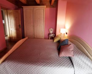 1 dormitorio con 1 cama grande y paredes de color rosa en Blumenstube en Sant’Orsola